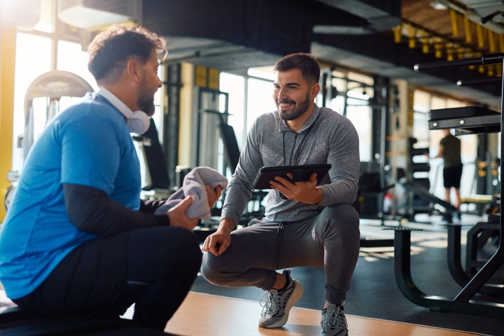 Photo of a male fitness coach advising an athlete during a workout