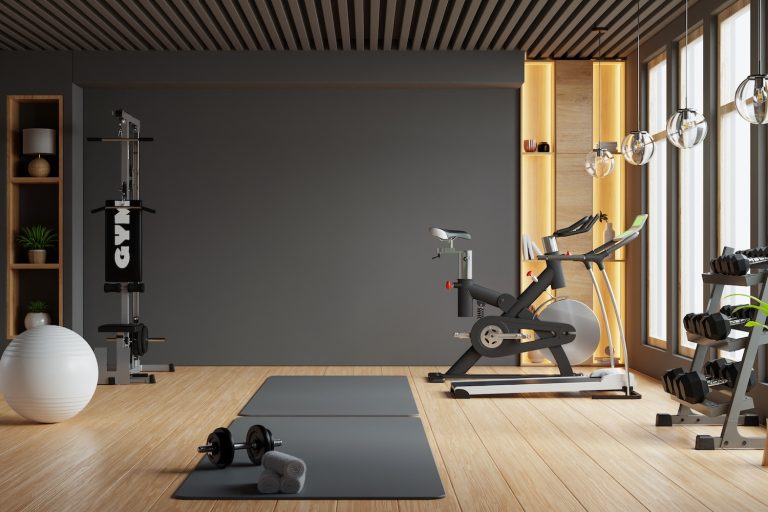 Modern gym interior with sport and fitness equipment on black wall background-